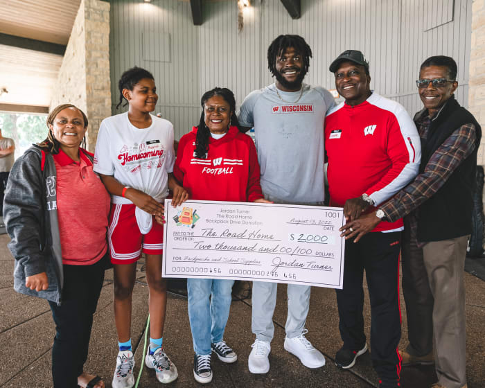 Wisconsin linebacker Jordan Turner presenting a check of $2,000 he donated to The Road Home (Credit: Troy Beckman, Team IFA)